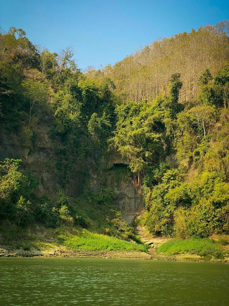 A river with trees and mountains in the background. Mountain river in the jungle. Nature landscape background. photo