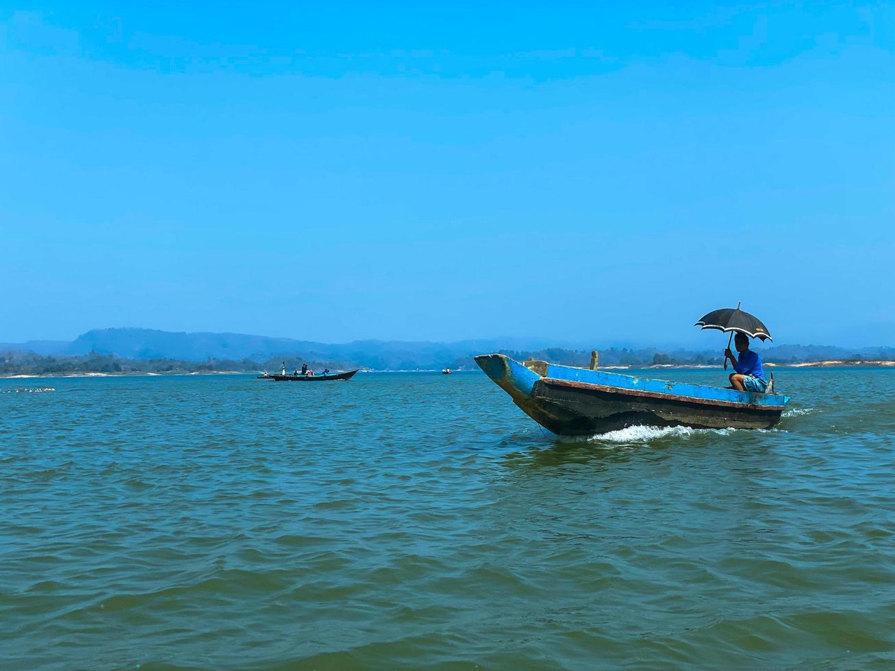 A boat with a man on it with an umbrella photo