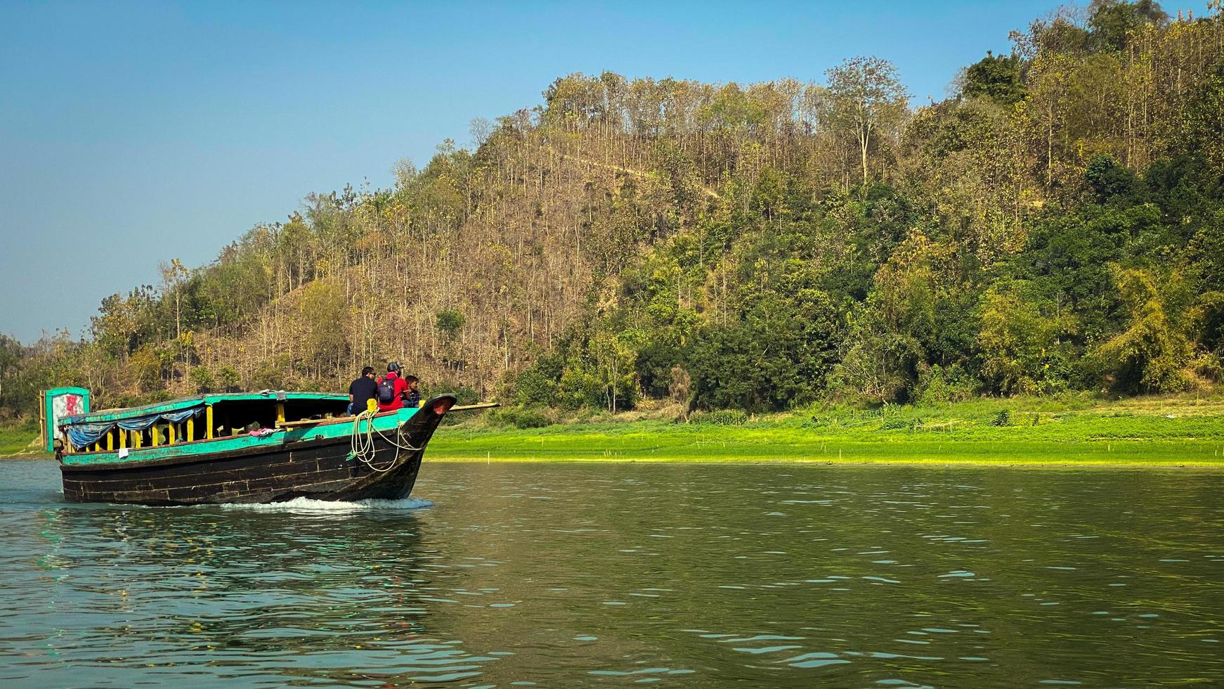 A boat on the river with a forest in the background photo