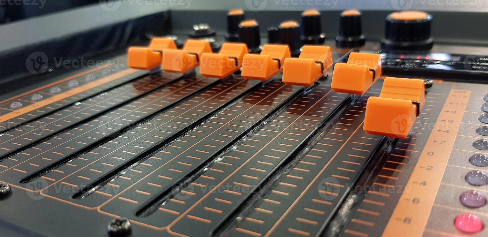 Close up orange button of sound mixer panel equipment for mixing or control audio system with selective focus technique. Technology, Tool and Digital device concept photo