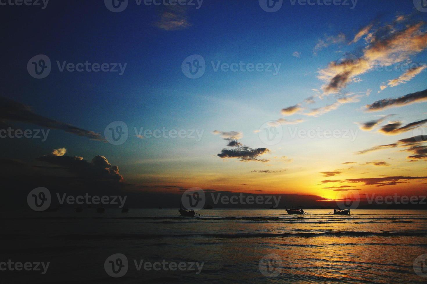 Beautiful Landscape view of sunlight shining from the dark clouds to the sea or ocean at sunset or sunshine time. Beauty of Nature concept photo