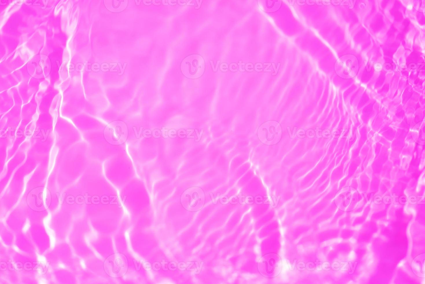 Purple water with ripples on the surface. Defocus blurred transparent pink colored clear calm water surface texture with splash and bubble. Water waves with shining pattern texture background texture photo