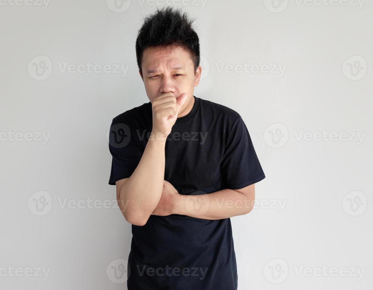 Young man is coughing and covering mouth with his hand photo