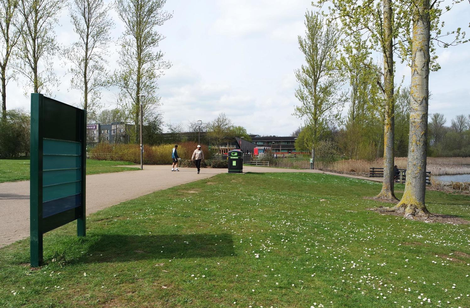 Low Angle View of Willen Lake Park with Local and Tourist Public Enjoying the Beauty of Lake and Park by Walking Around with Their Families. Footage Was Captured on 09-April-2023 at Milton Keynes UK photo