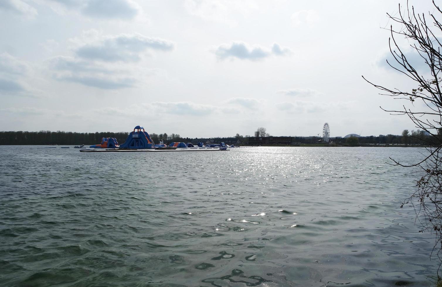 Low Angle View of Willen Lake Park with Local and Tourist Public Enjoying the Beauty of Lake and Park by Walking Around with Their Families. Footage Was Captured on 09-April-2023 at Milton Keynes UK photo