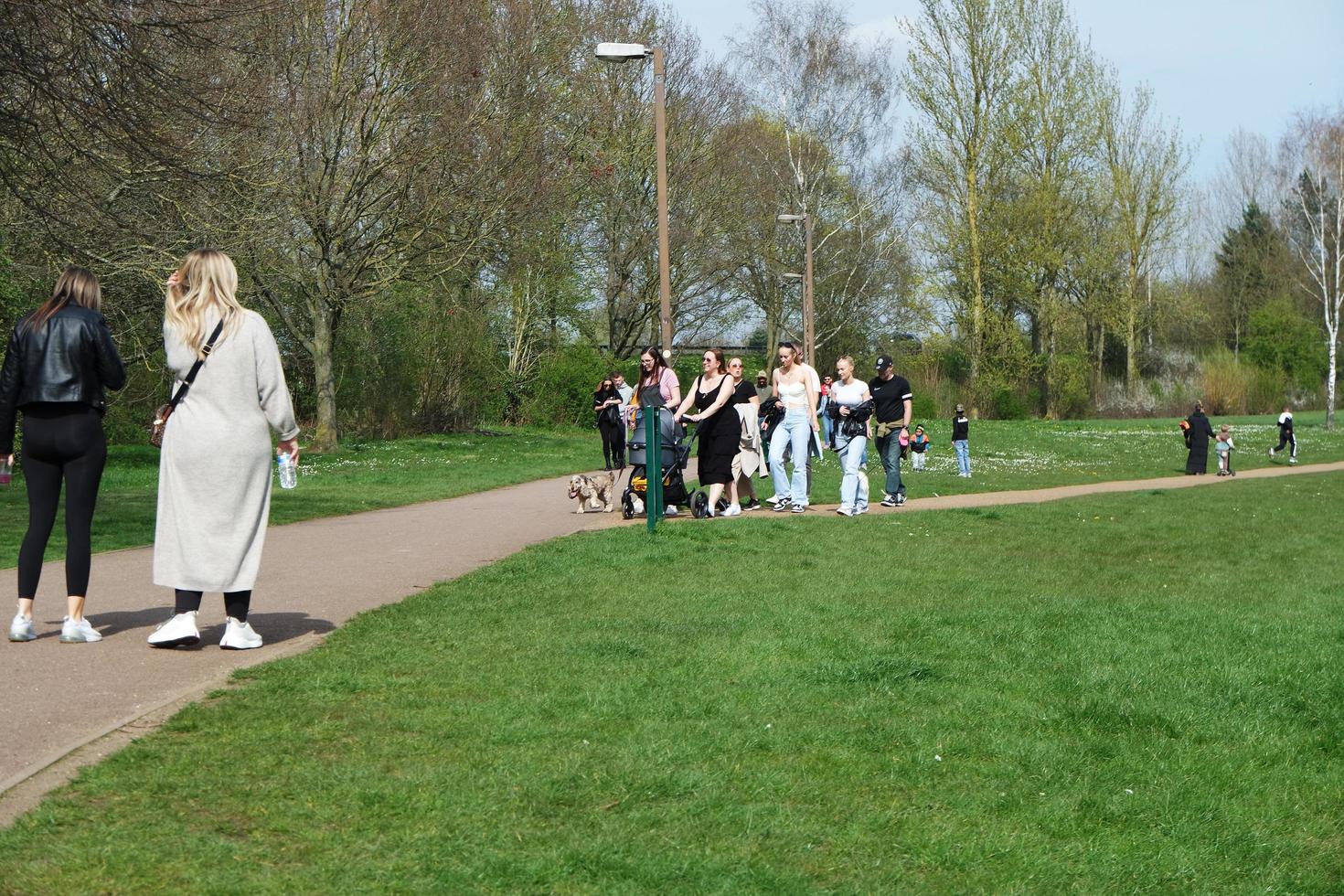 Low Angle View of Willen Lake Park with Local and Tourist Public Enjoying the Beauty of Lake and Park by Walking Around with Their Families. Footage Was Captured on 09-April-2023 at Milton Keynes UK photo