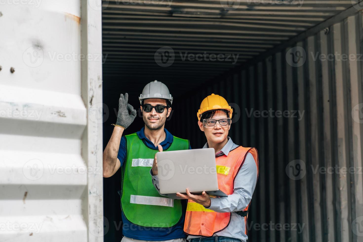 Team Engineer and worker wear safety uniform check control loading freight cargo container use computer laptop at commercial dock warehouse,transportation import,export logistic industrial service photo