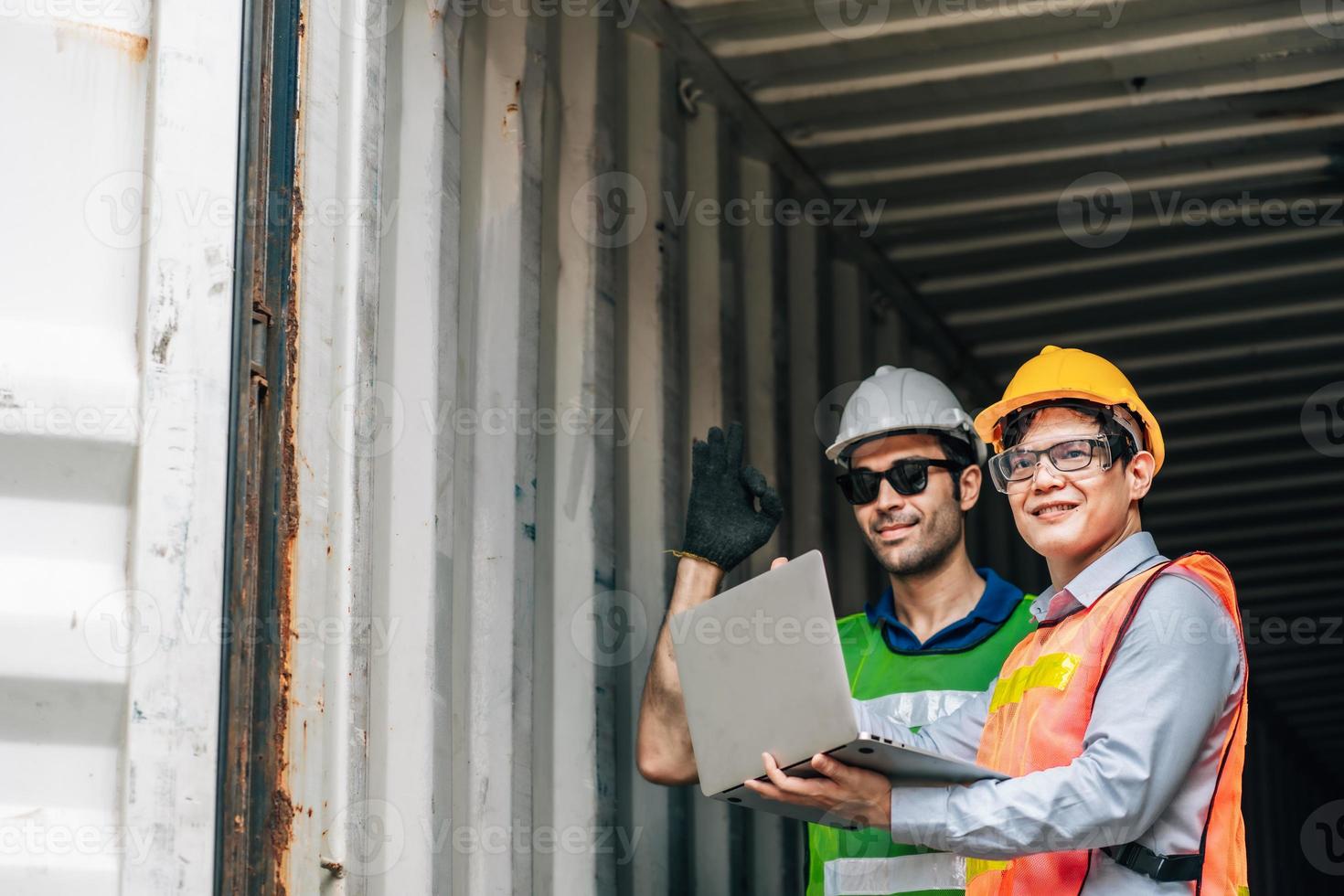 Team Engineer and worker wear safety uniform check control loading freight cargo container use computer laptop at commercial dock warehouse,transportation import,export logistic industrial service photo