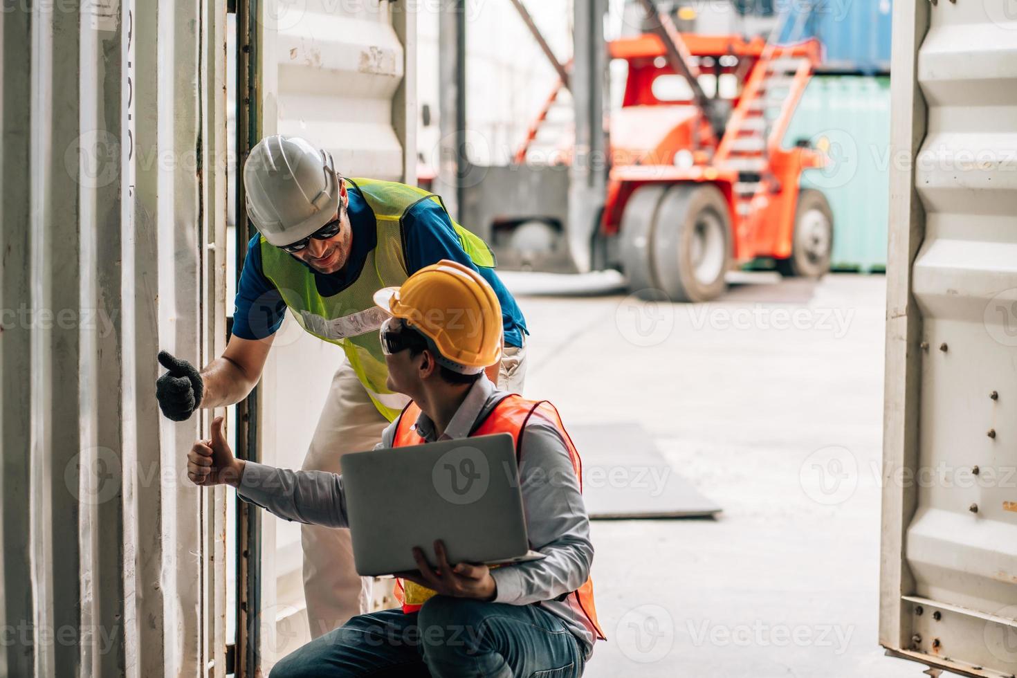 Team Engineer and worker wear safety uniform check control loading freight cargo container use computer laptop at commercial dock warehouse,transportation import,export logistic industrial service photo