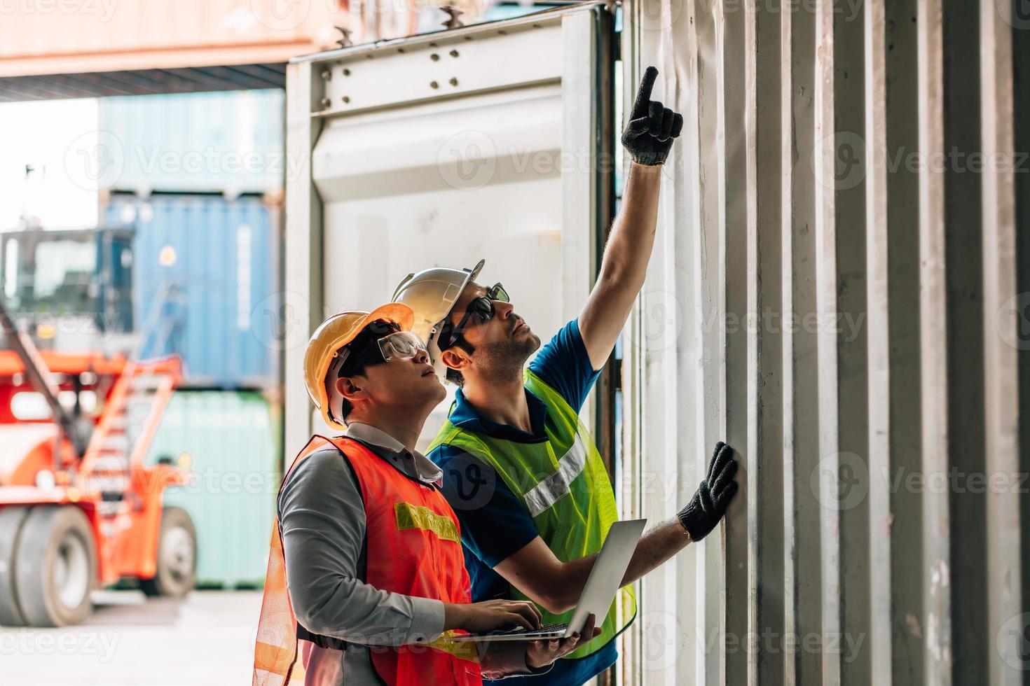 Team Engineer and worker wear safety uniform check control loading freight cargo container use computer laptop at commercial dock warehouse,transportation import,export logistic industrial service photo