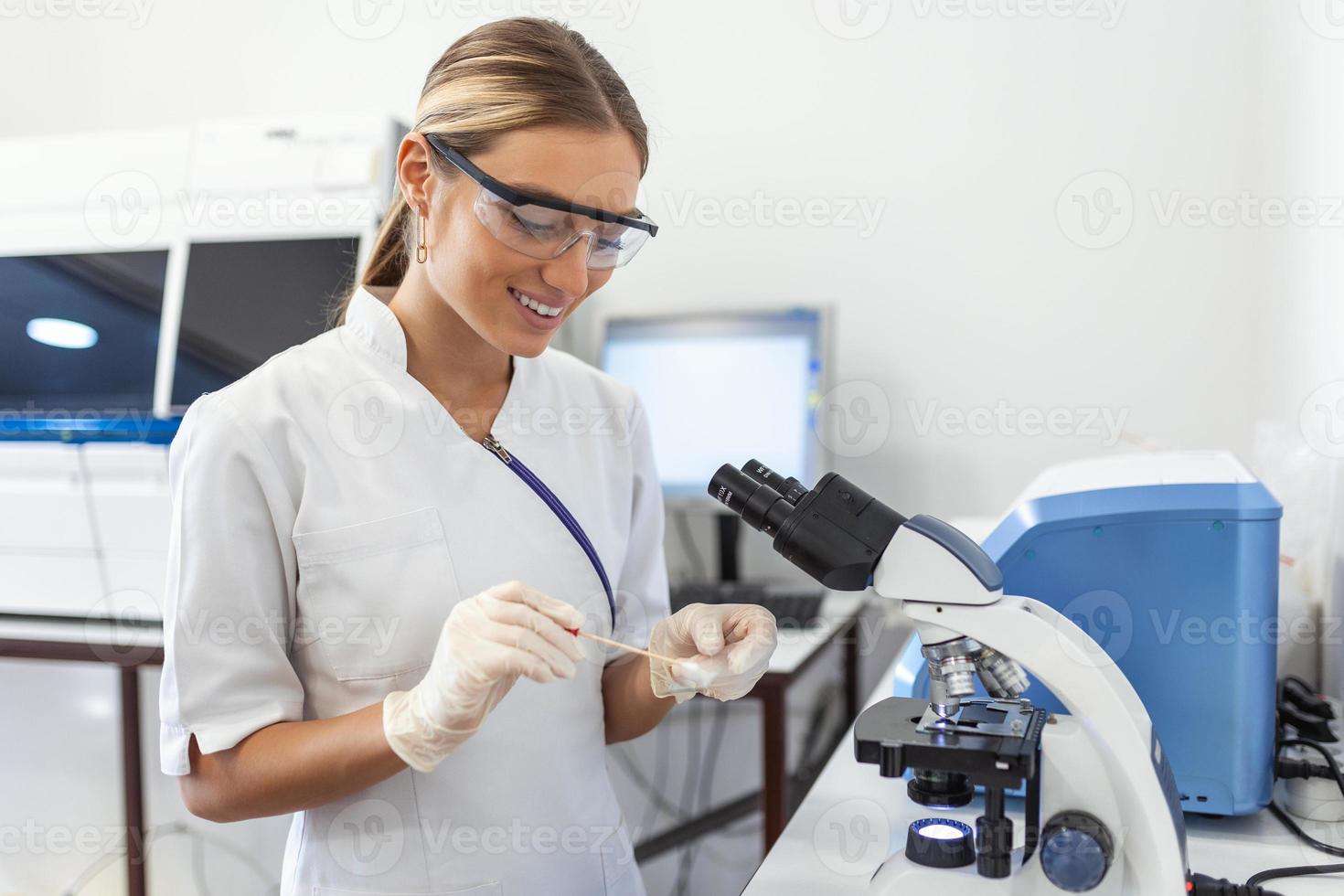 Medical Science Laboratory Beautiful Scientist Looking Under Microscope Does Analysis of Test Sample. Young Specialists, Using Advanced Technology Equipment photo