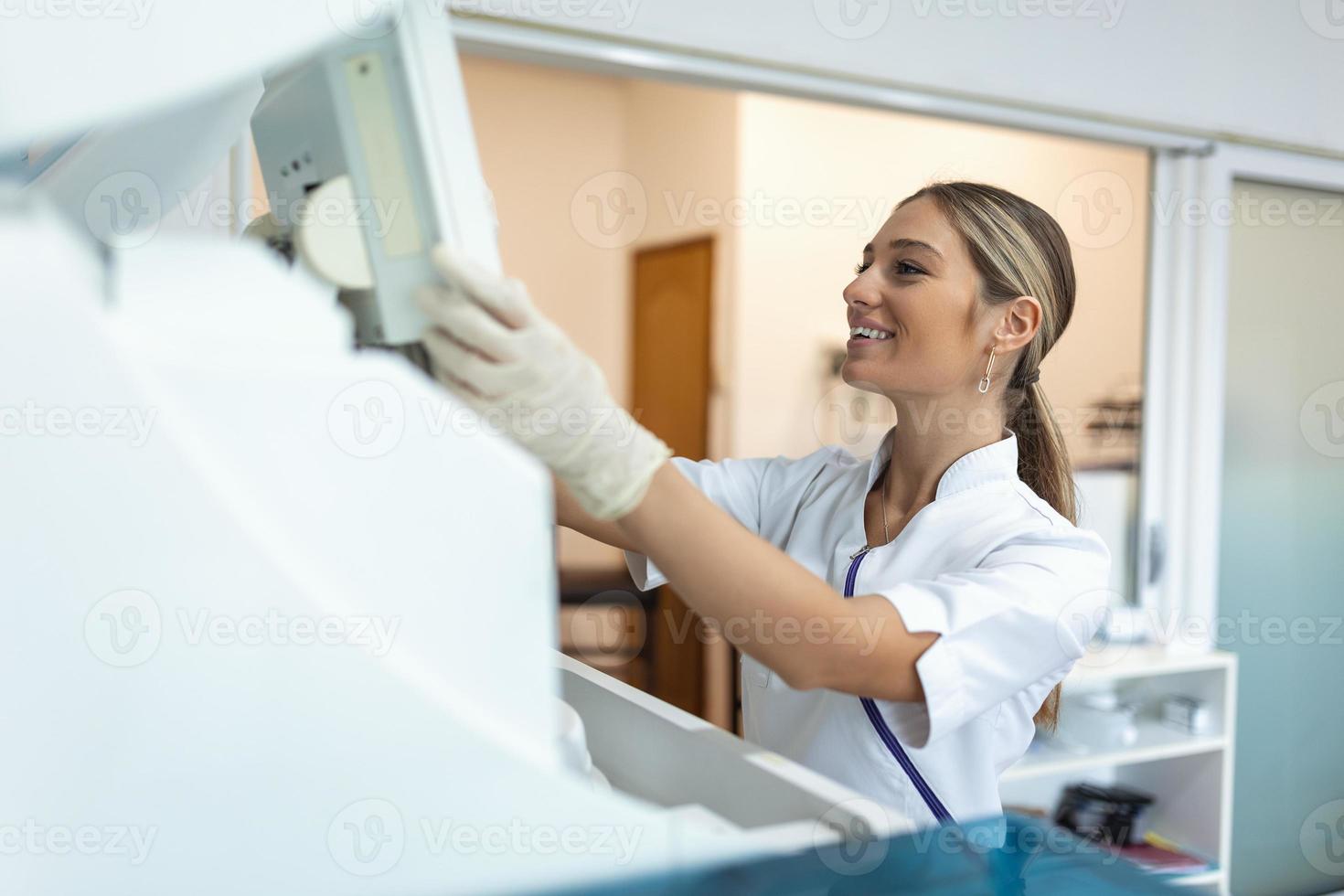 Lab tech loading samples into a chemistry analyzer. female lab tech loading specimen for coagulation test analysis photo