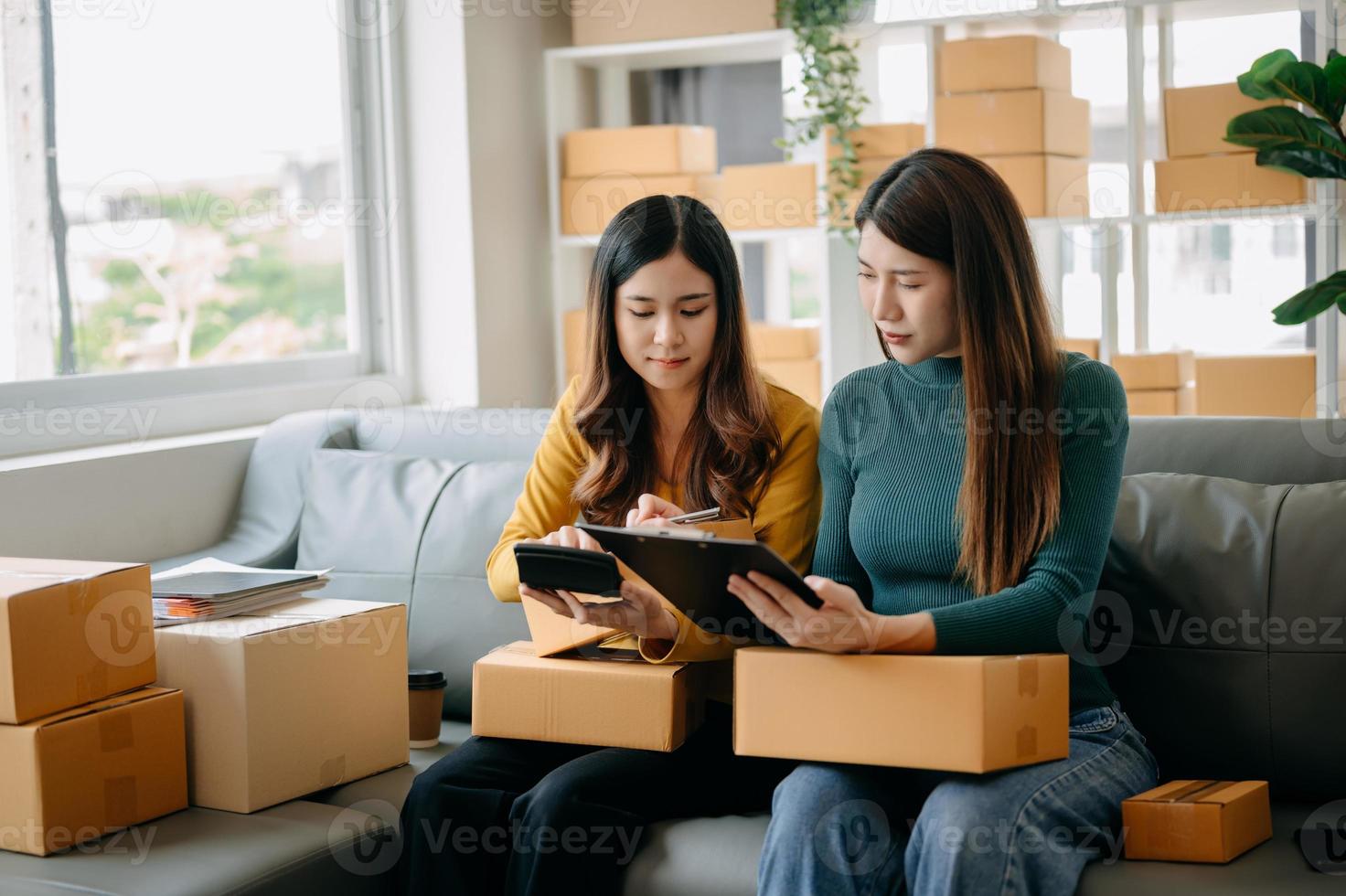 Starting small businesses SME owners, two check online orders Selling products working with boxs freelance work at home office using tablet and laptop marketing, as online shopping concept photo