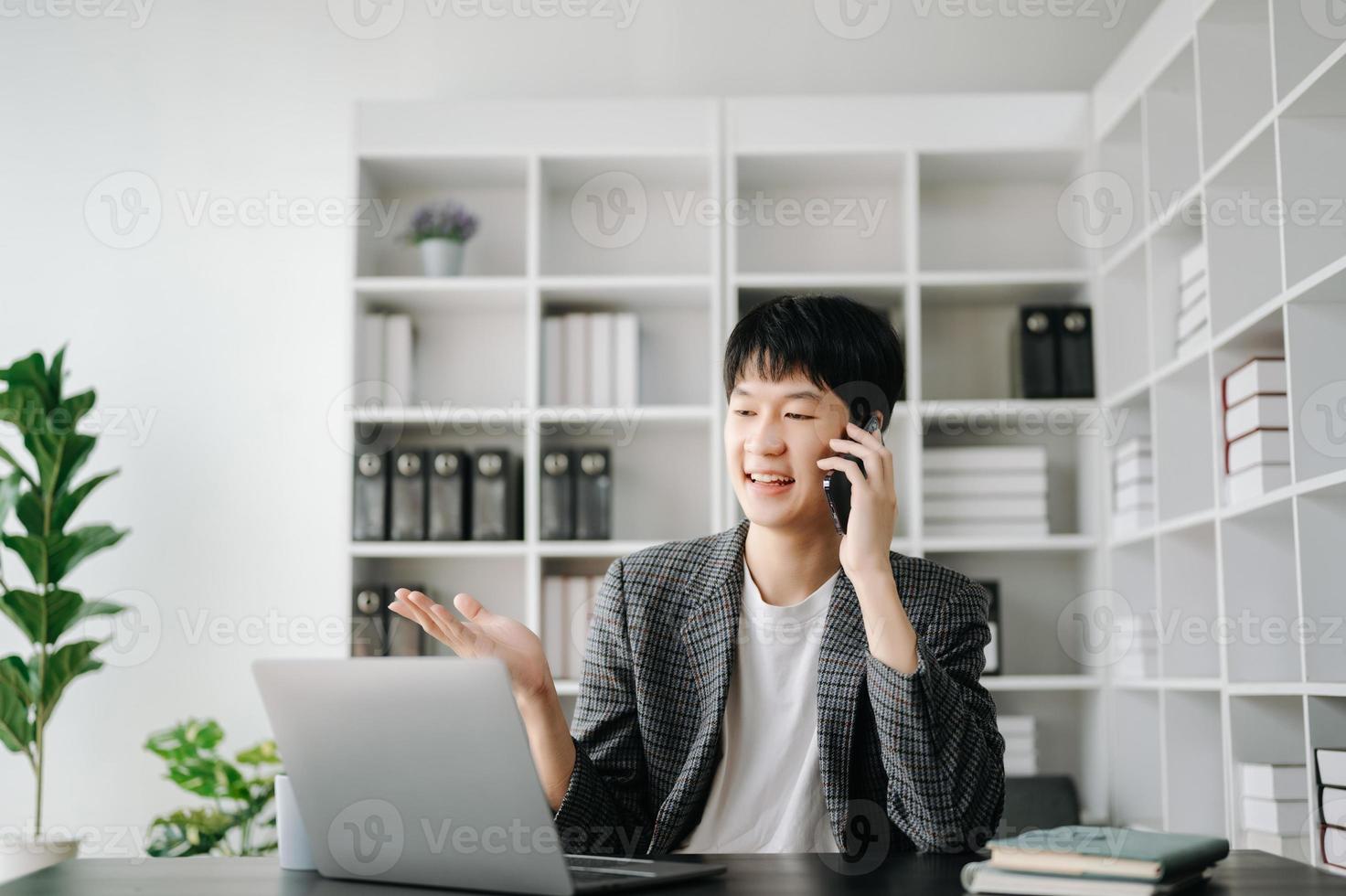 joven negocio hombre trabajando a moderno oficina con computadora portátil, tableta y tomando notas en el papel. foto