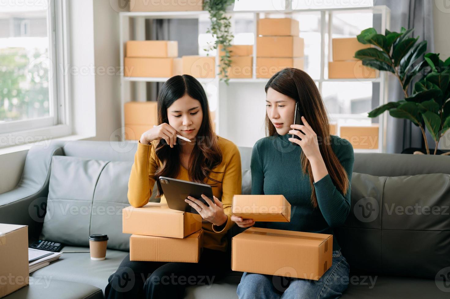 Starting small businesses SME owners, two check online orders Selling products working with boxs freelance work at home office using tablet and laptop marketing, as online shopping concept photo