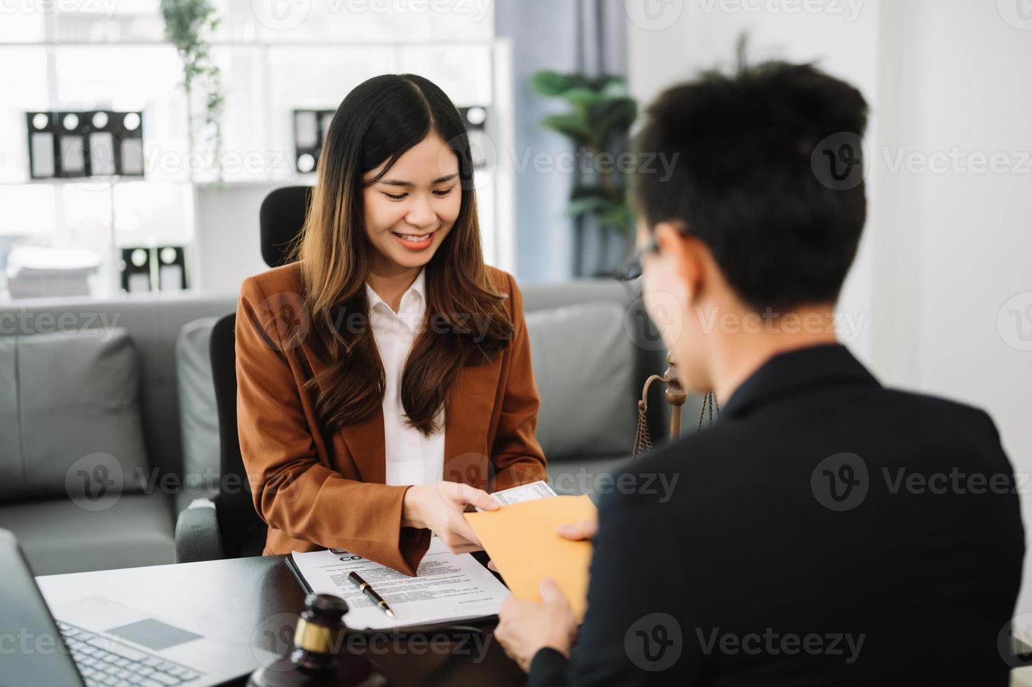 justice and law concept.passing bribe money in the envelop at office. businesswoman hand taking bribe money from male photo