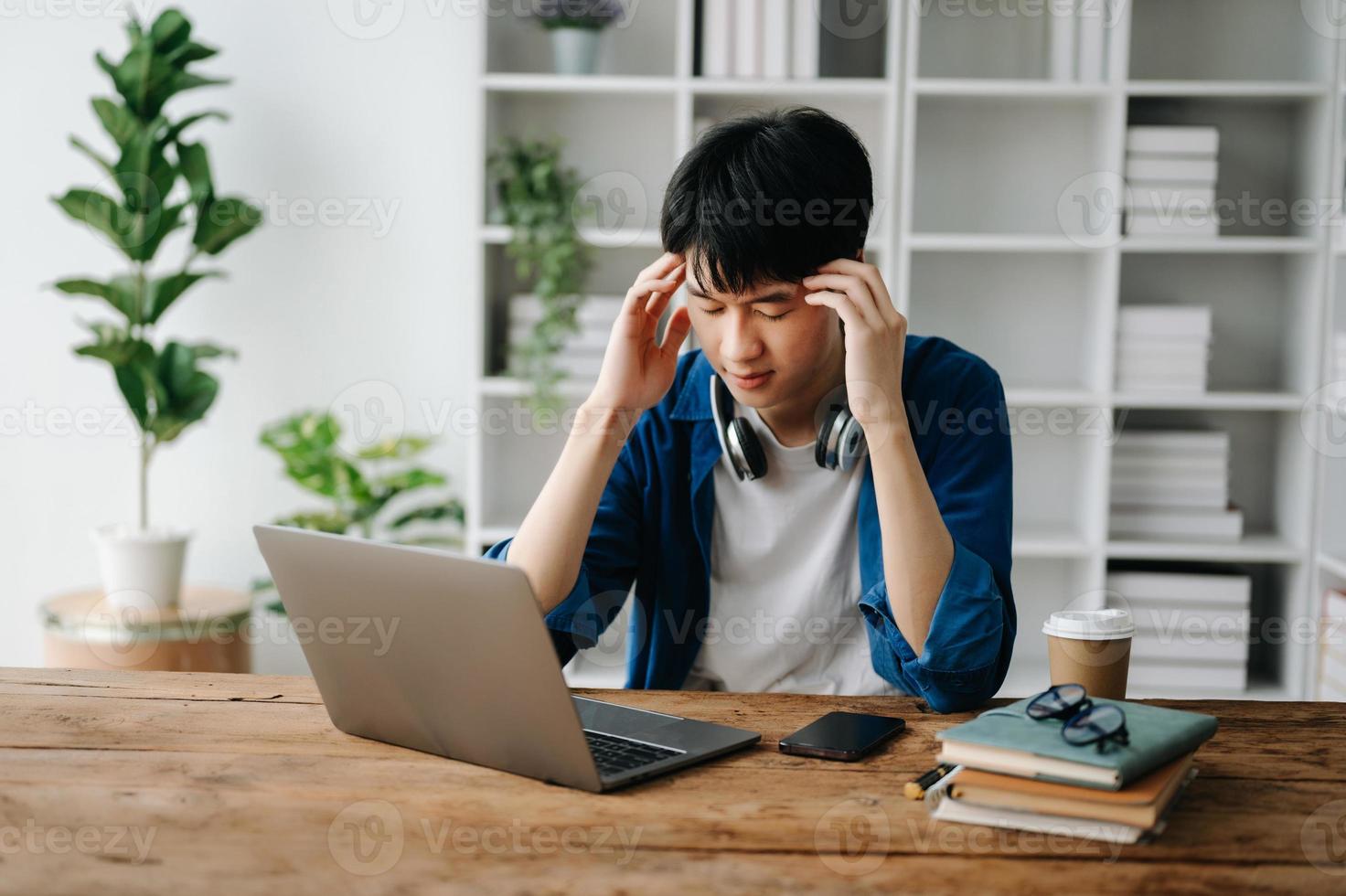 Asian business man is stressed, bored, and overthinking from working on a tablet at the office. photo