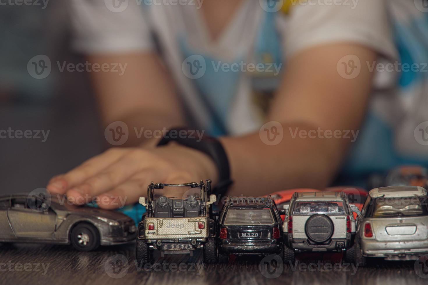 colorful toy cars arranged in a row on the floor during a child's play photo