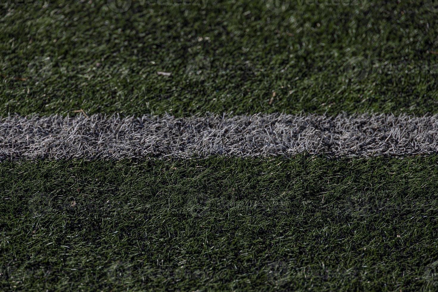 green background of artificial turf football field in closeup photo