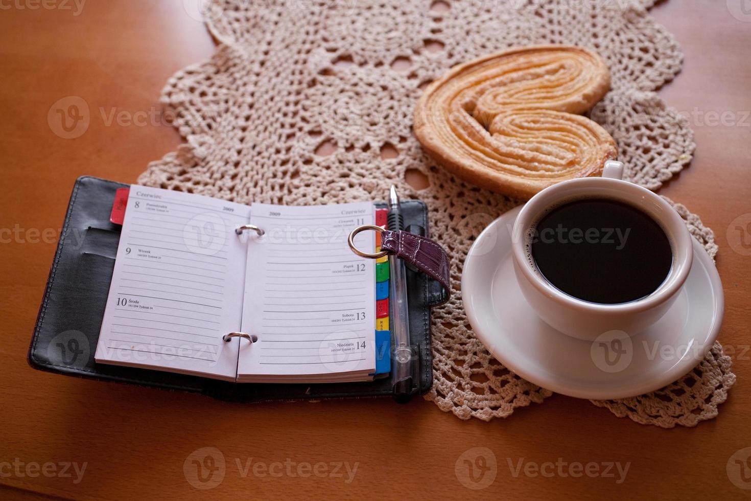white cup of black coffee and a sweet buttery cookie on the table photo