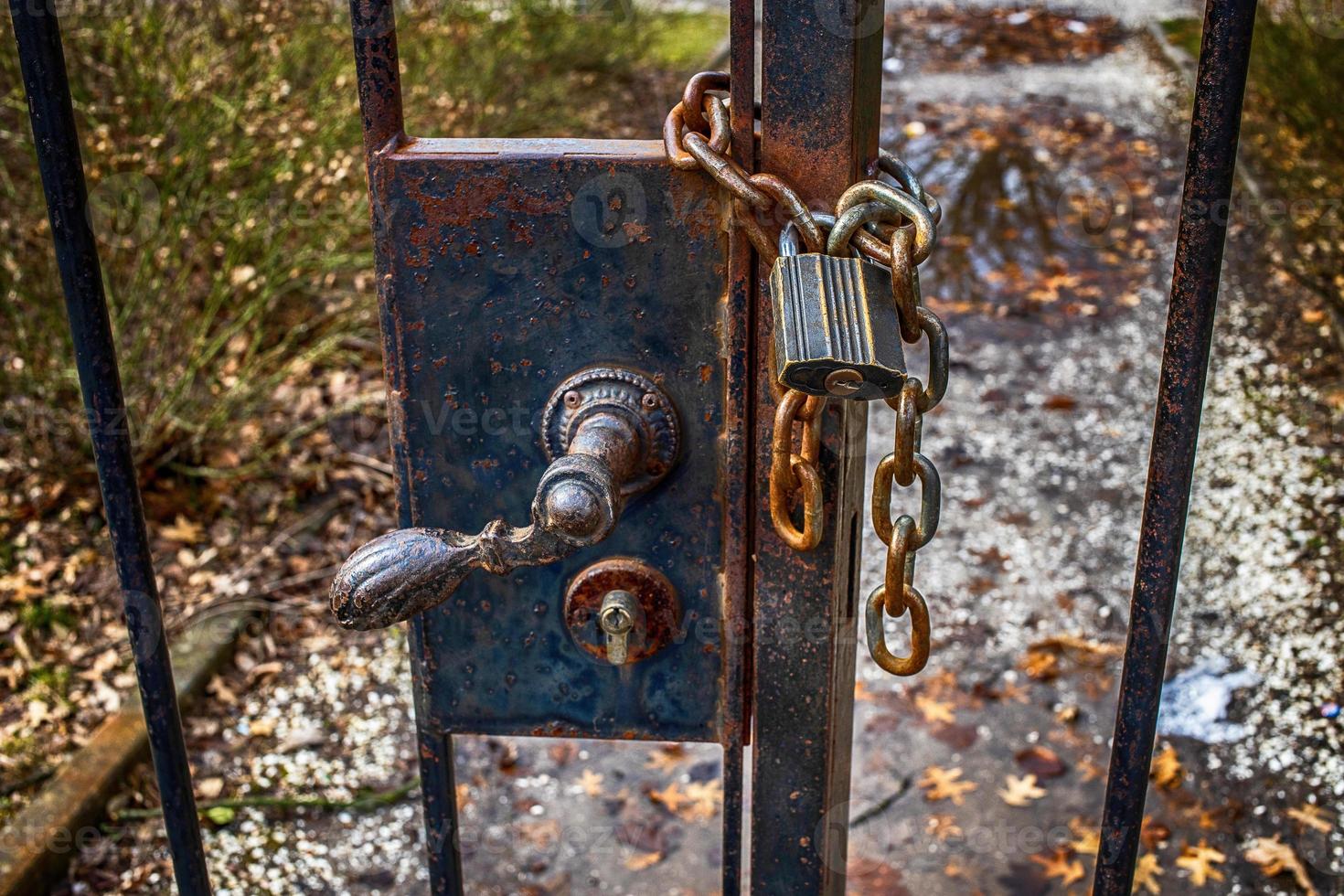 old retro vintage door fence with a large lock closed on a chain photo
