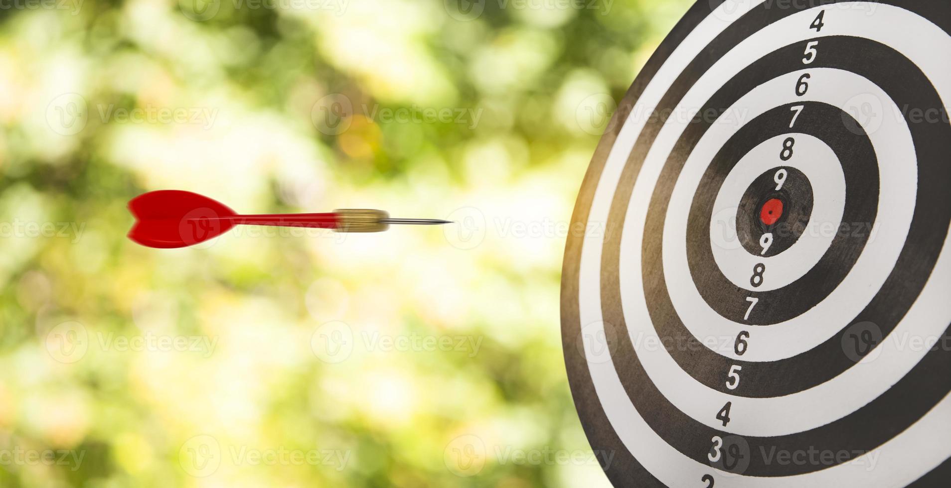 New Target and goal as concept, Close up shot of the dart arrow hit on bullseye, red dart arrow hitting in the target center of dartboard Target hit in the center, challenge in business marketing. photo