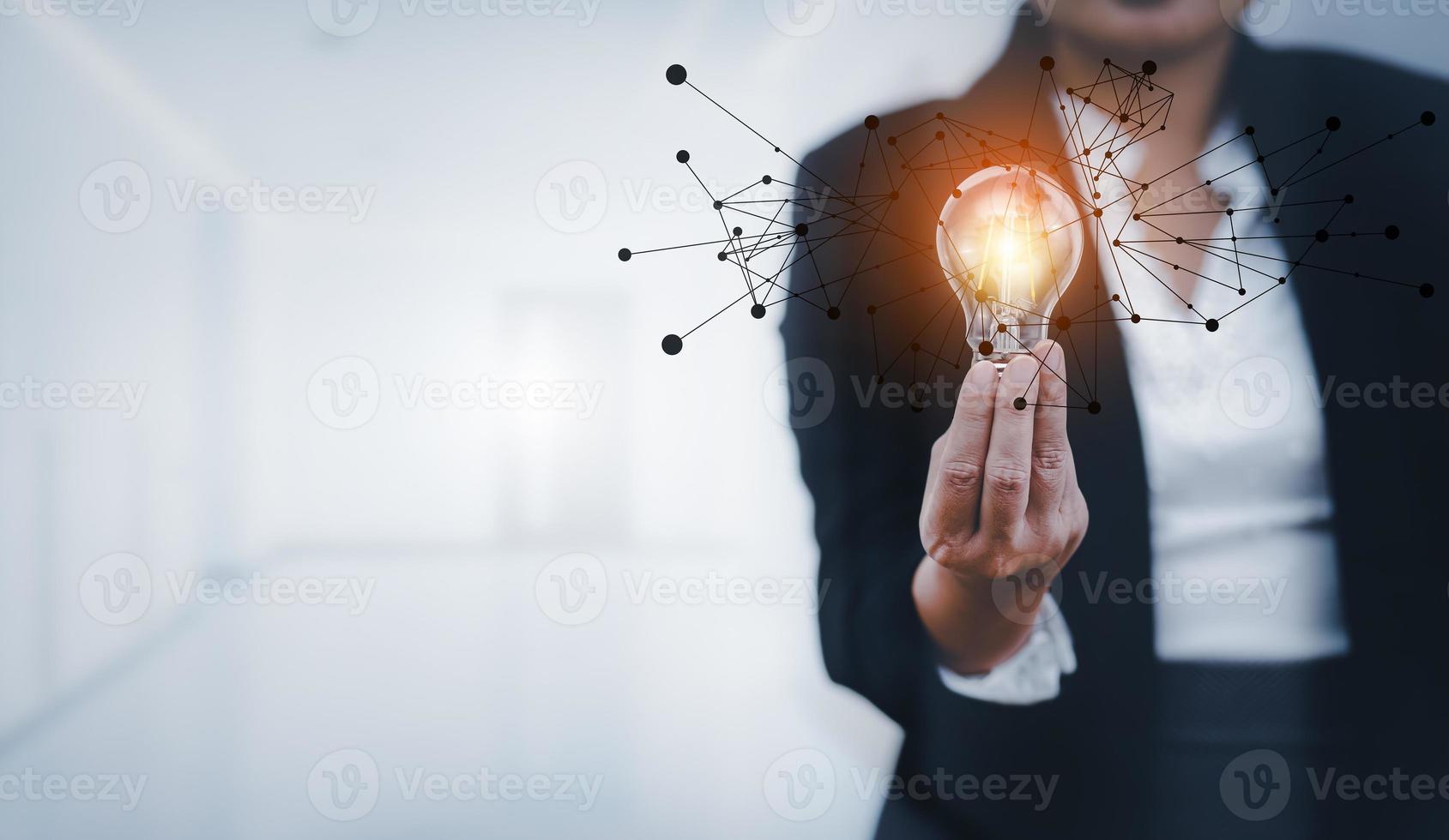 Businesswoman hand holding light bulb with line connect and working on the desk, Creativity and innovation are keys to success.Concept of new idea and innovation with energy and power , working. photo