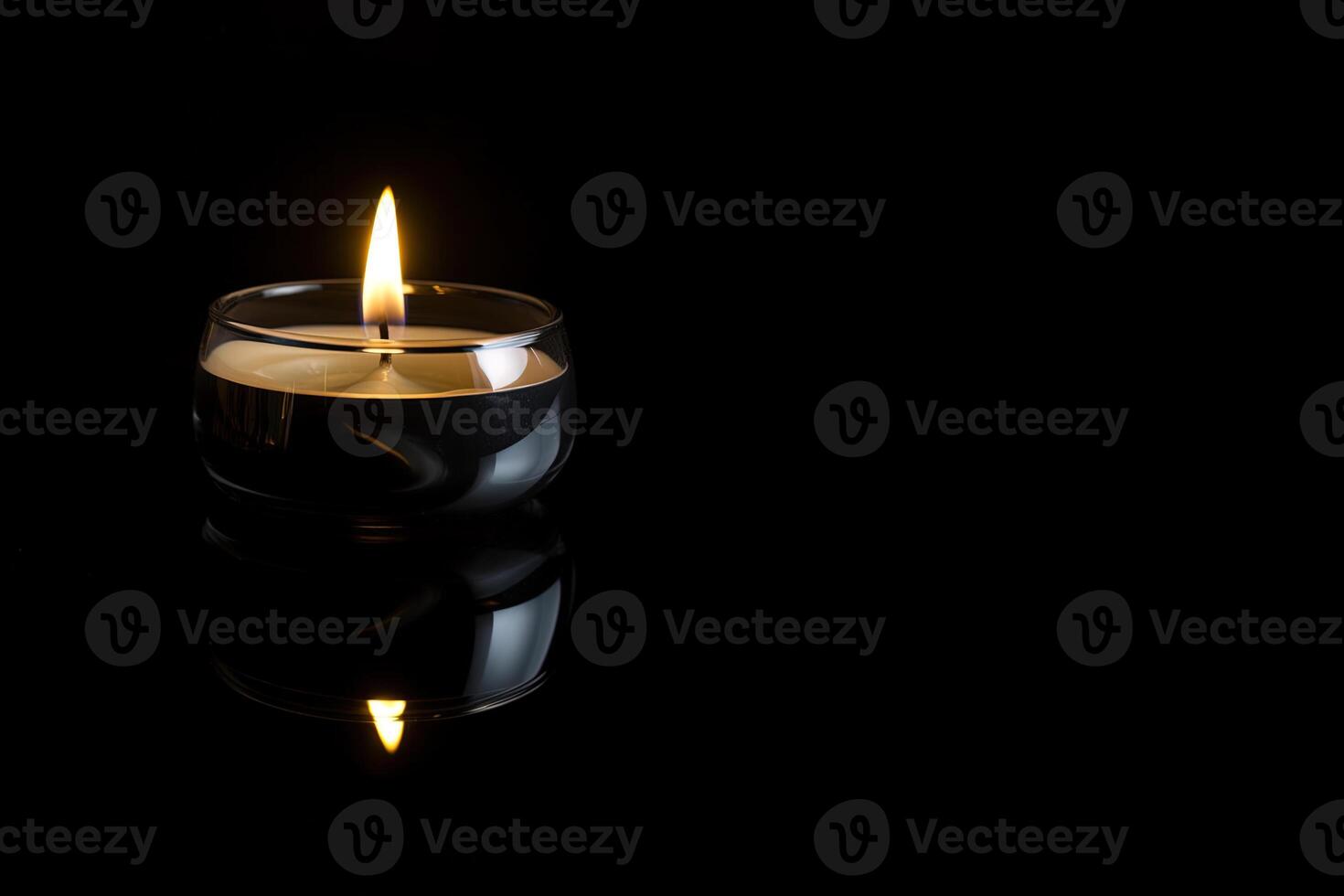 a candle is lit in the dark conveying memorial death and hope with copy space. photo
