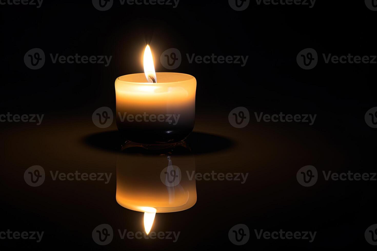 a candle is lit in the dark conveying memorial death and hope with copy space. photo