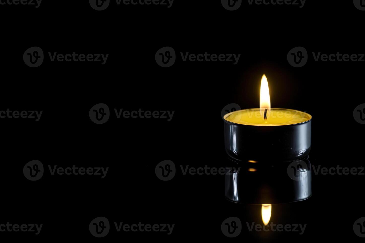 a candle is lit in the dark conveying memorial death and hope with copy space. photo