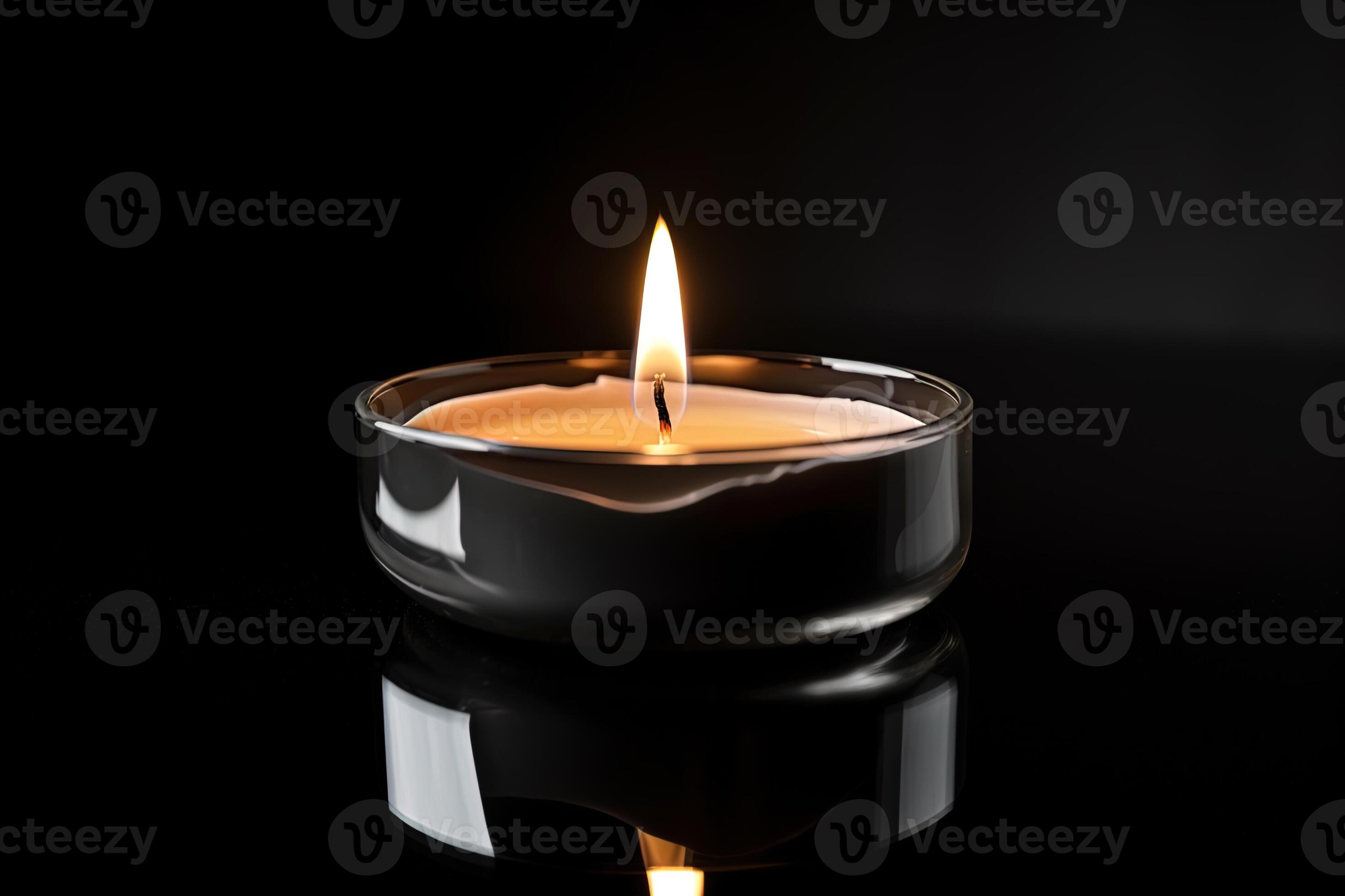 a candle is lit in the dark conveying memorial death and hope. 23128082