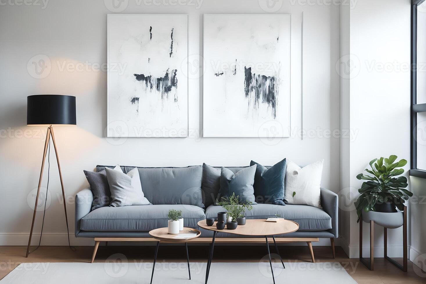 In the interior of a living room with chairs seated at a table beneath a metal light, there is a painting on a white wall above the sofa with cushions, photo