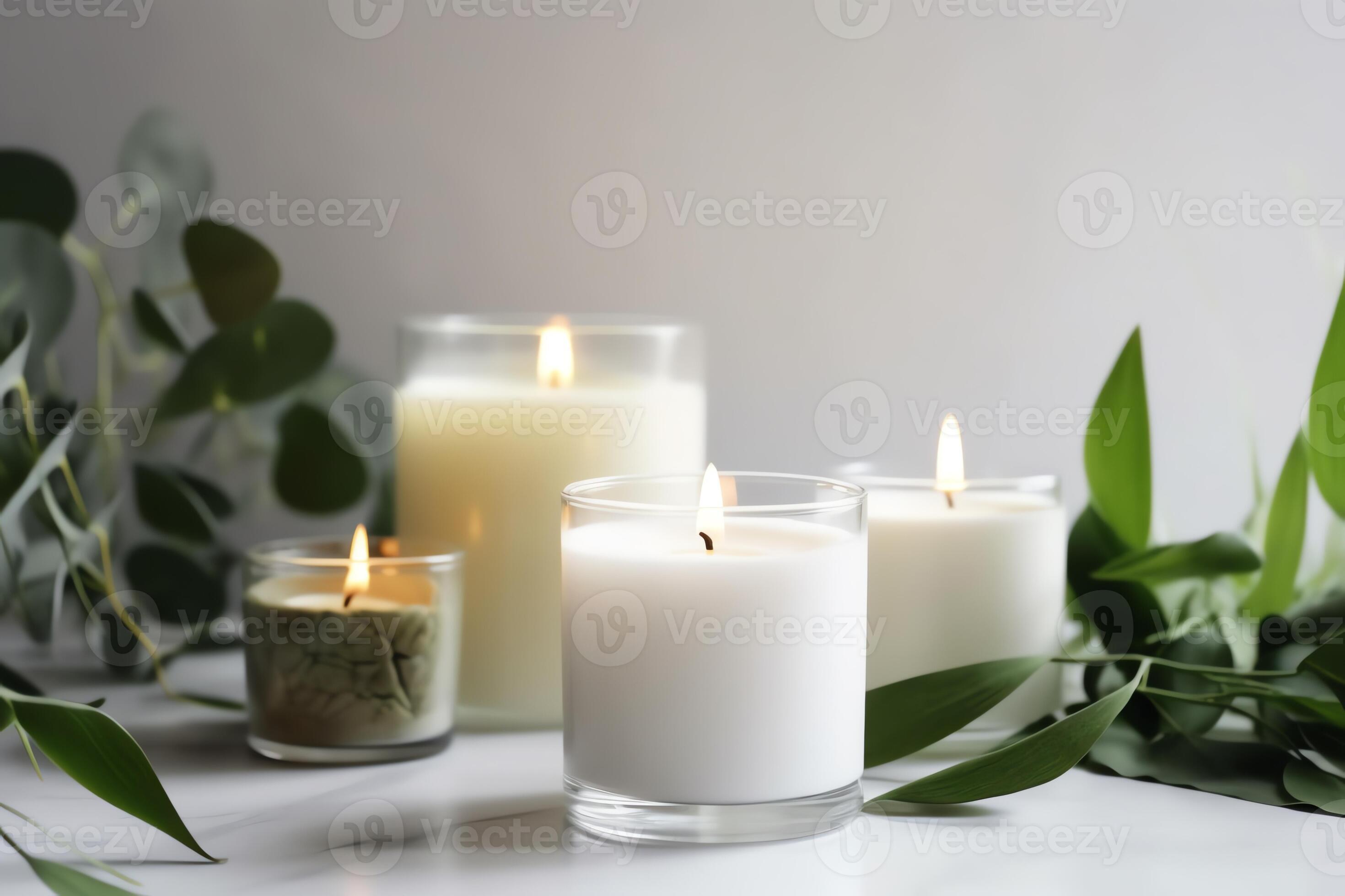 Scented White Candles With A Green Plant Background On White Surface