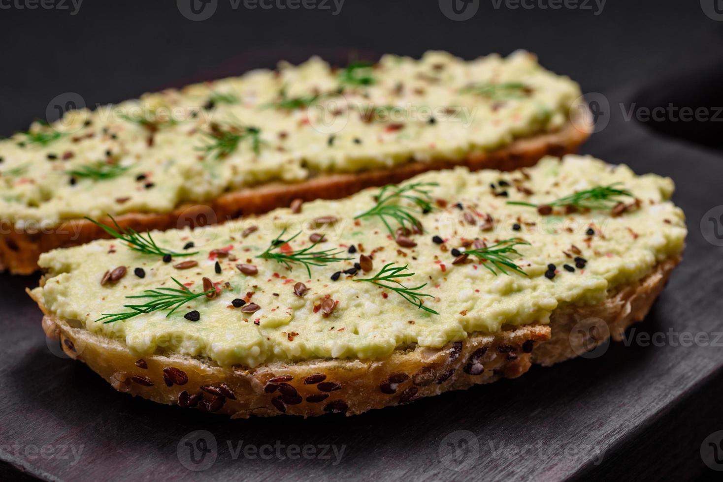 Grilled toast with avocado paste, eggs, cream cheese, salt, spices and herbs photo
