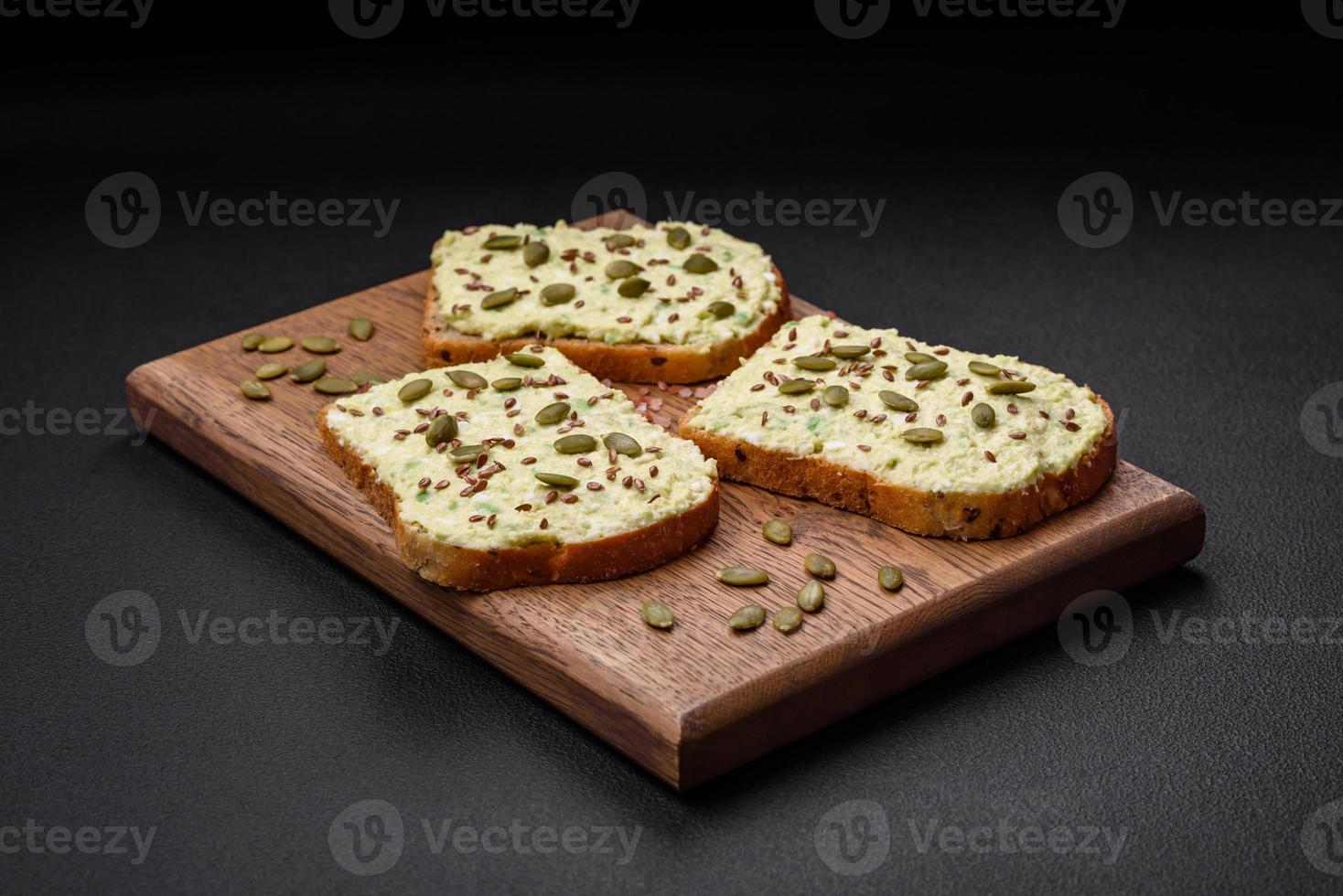 Grilled toast with avocado paste, eggs, cream cheese, salt, spices and herbs photo