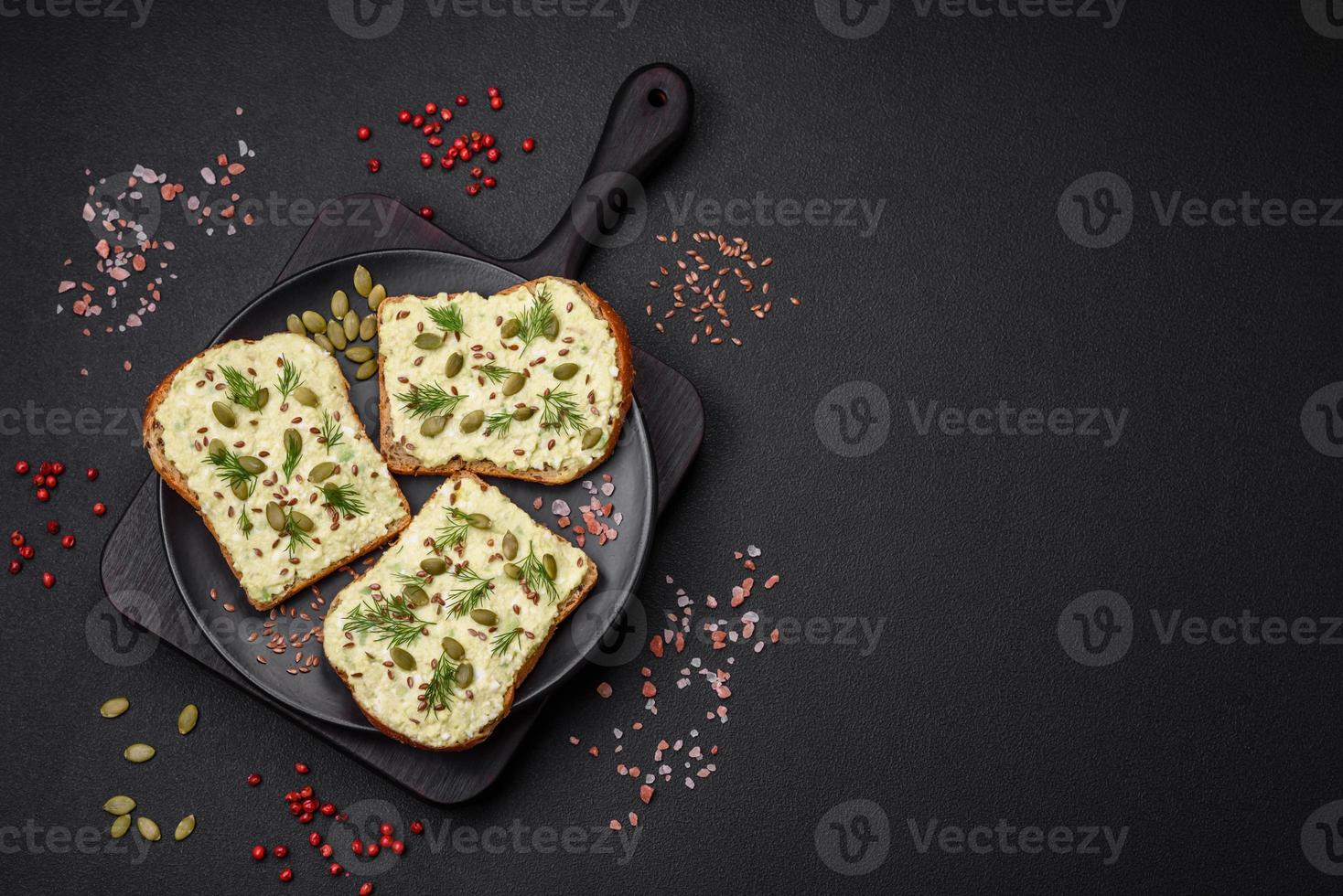 Grilled toast with avocado paste, eggs, cream cheese, salt, spices and herbs photo