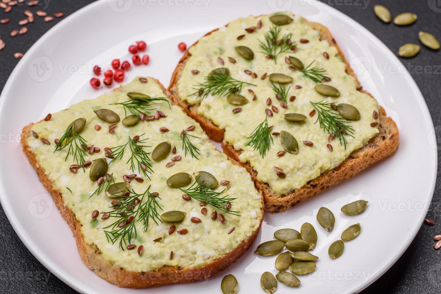 Grilled toast with avocado paste, eggs, cream cheese, salt, spices and herbs photo