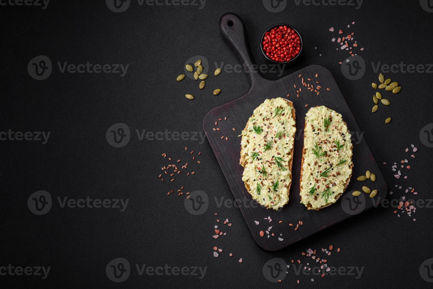 Grilled toast with avocado paste, eggs, cream cheese, salt, spices and herbs photo