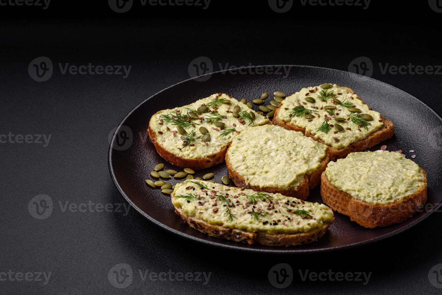 Grilled toast with avocado paste, eggs, cream cheese, salt, spices and herbs photo