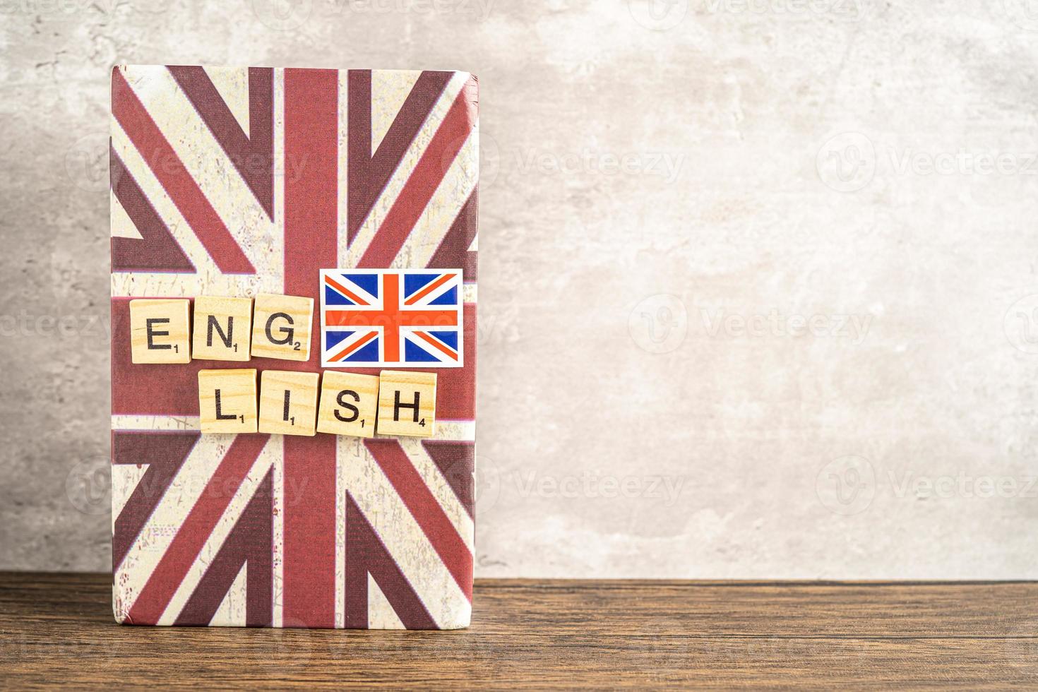 Word English on book with United Kingdom flag, learning English language courses concept. photo