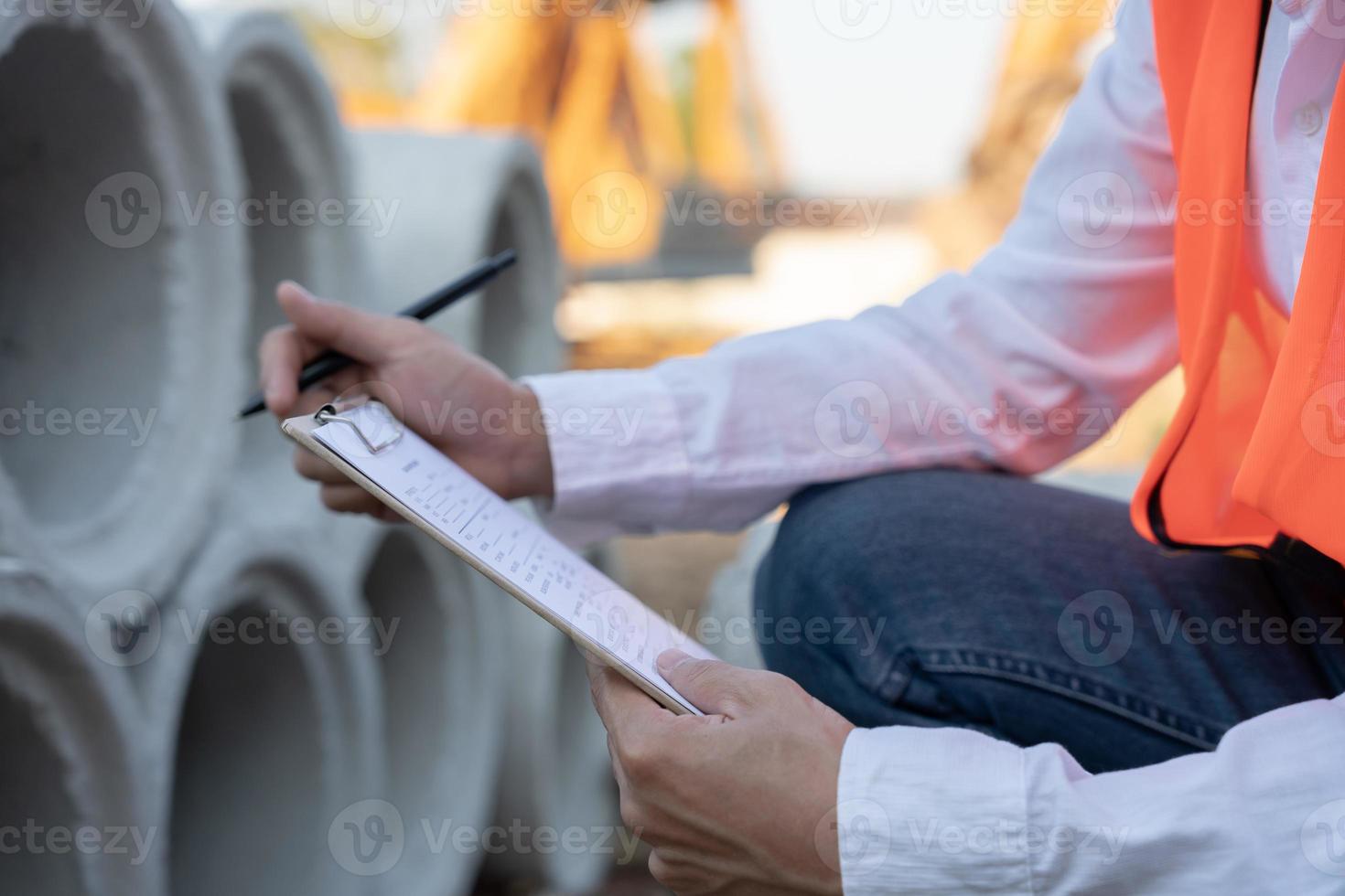 inspector or engineer is inspecting construction house using a checklist. Engineers and architects or contactor count materials for construction. Building, check, insurance house, quality, foreman. photo