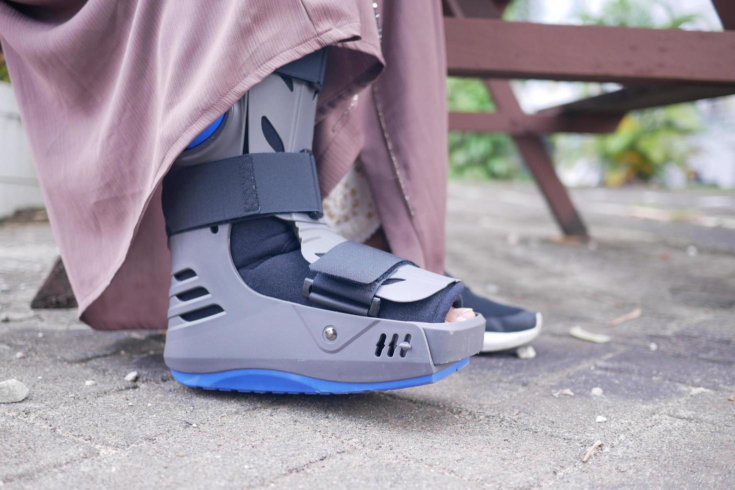 women broken feet with a grey plastic boot ankle brace injury protecting boot 23146864 Stock