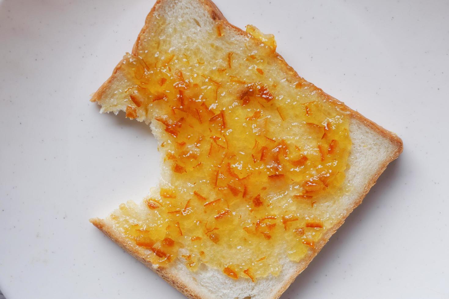 Spreading jam on on slice bread. photo