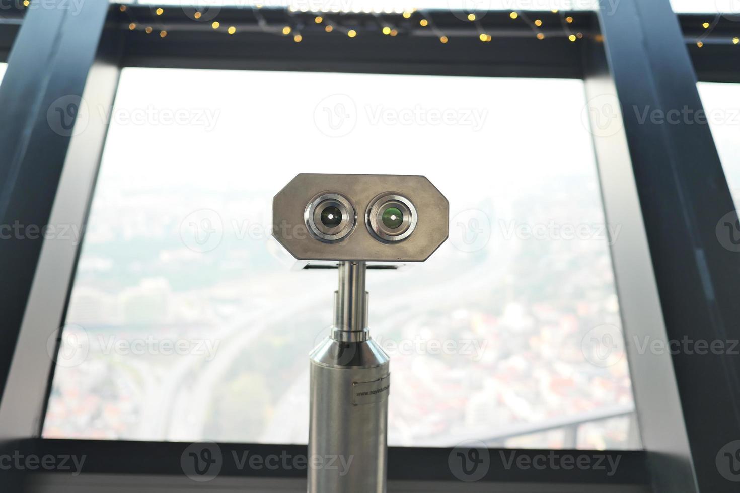 Coin-operated binoculars looking out over city , photo