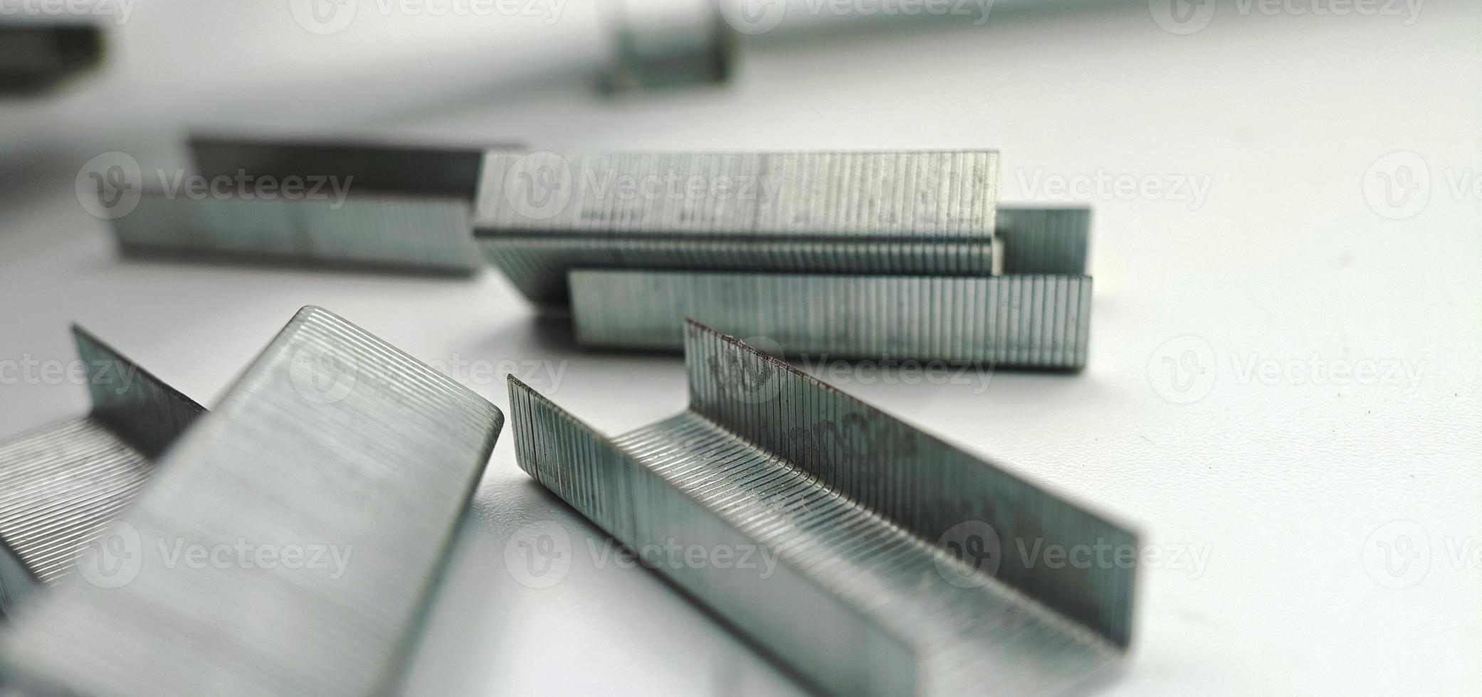 macro shot, stack of metal staples for stapler on a white background photo