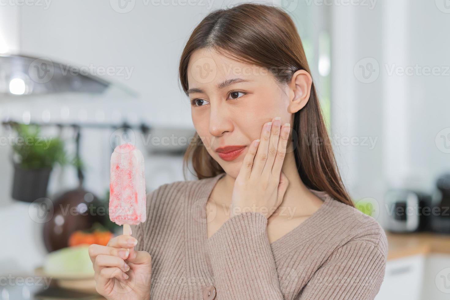 Closing eyes asian young woman touching cheek, face expression from toothache, tooth decay or sensitivity, Having  teeth problem or inflammation, suffering from health. Sensitive teeth people. photo