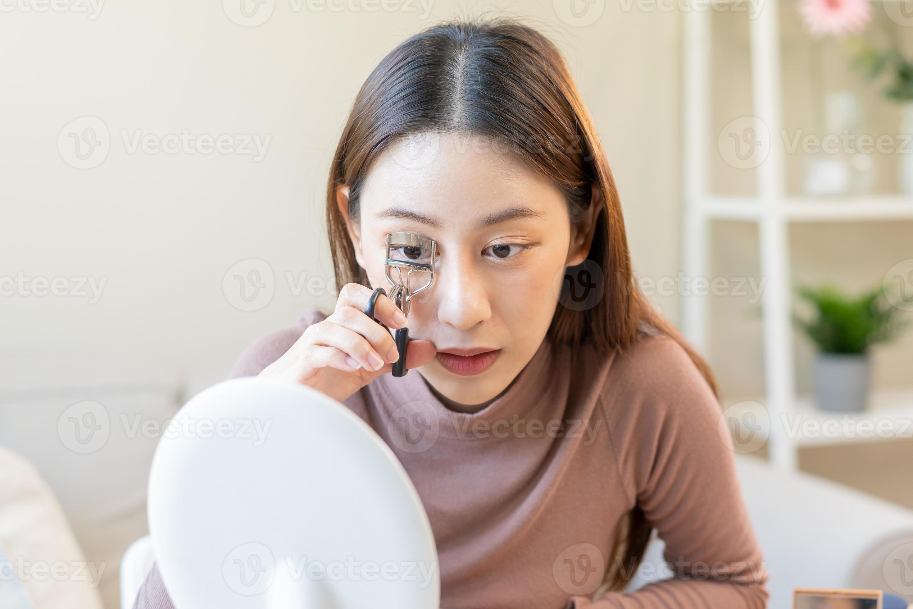 Beauty concept, beautiful asian young woman, girl makeup face by using an eyelash curler to curl