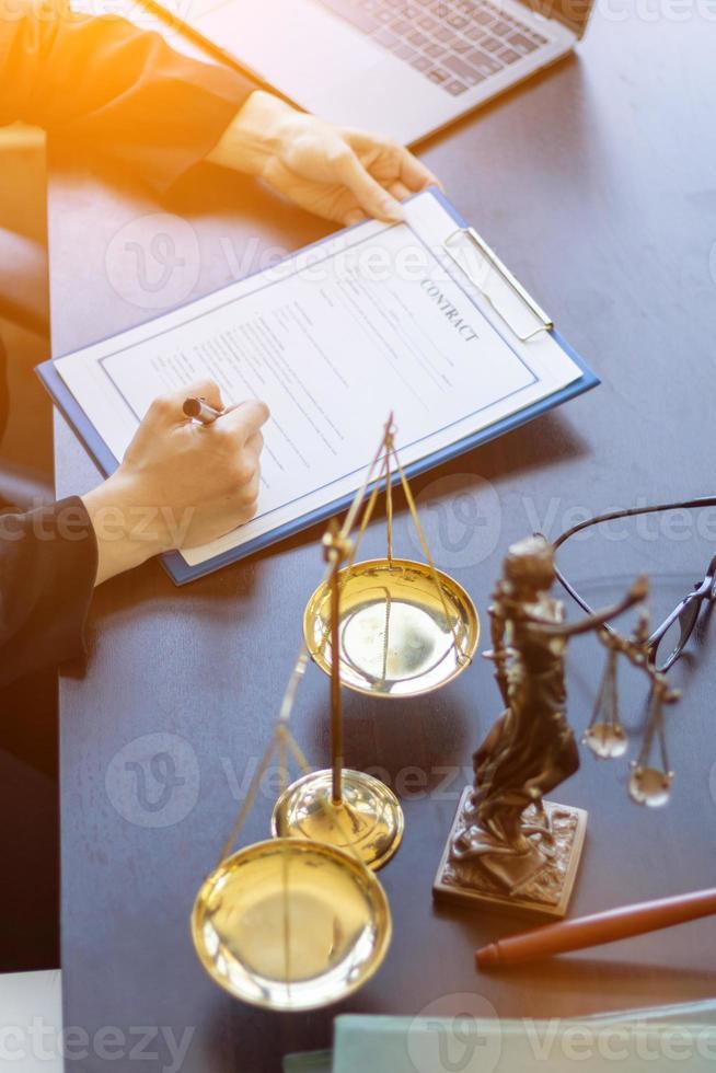 Lawyer holding contract documents in hand and preparing to sign a consulting contract for a team of business people who need legal advice to run their business in accordance with the law photo