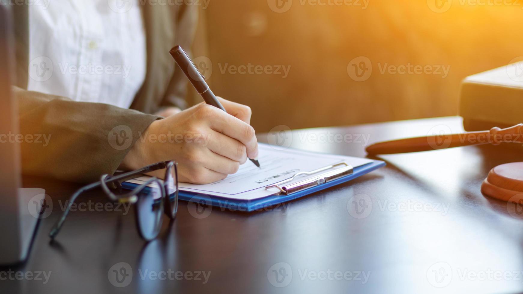 Lawyer holding contract documents in hand and preparing to sign a consulting contract for a team of business people who need legal advice to run their business in accordance with the law photo