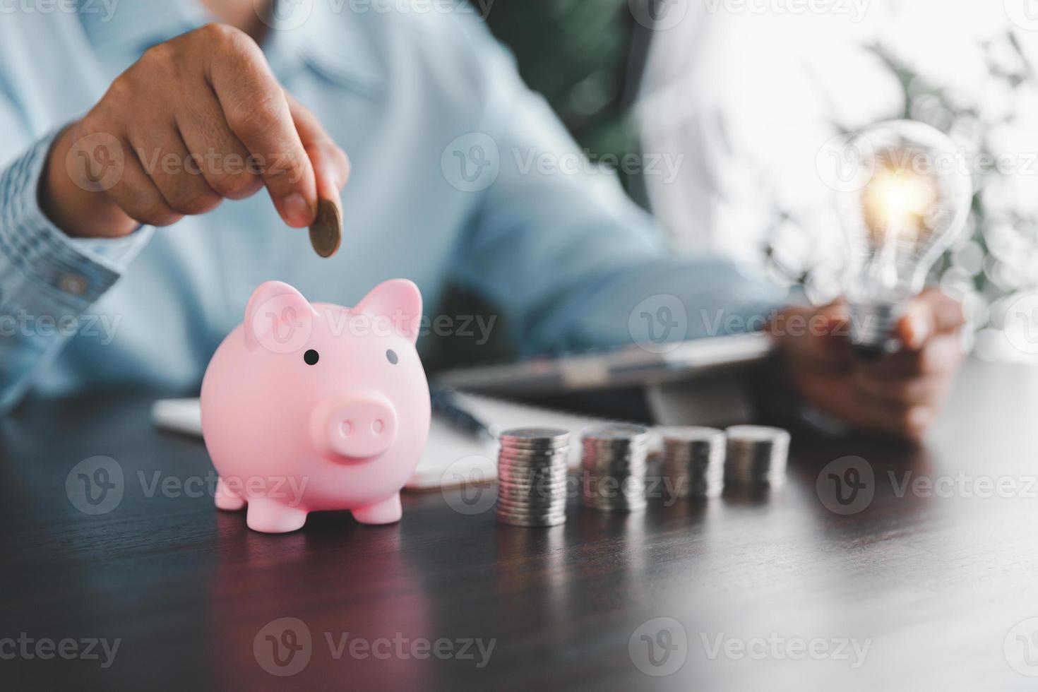 mujer de negocios mano participación bombilla y poniendo moneda en cerdito banco. idea de ahorro energía y contabilidad Finanzas en hogar y familia, salvar mundo y energía fuerza. salvar energía plan concepto foto